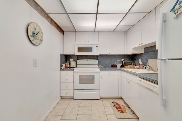 kitchen featuring white appliances, light tile flooring, tasteful backsplash, white cabinets, and sink