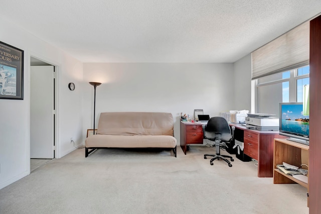 carpeted office featuring a textured ceiling