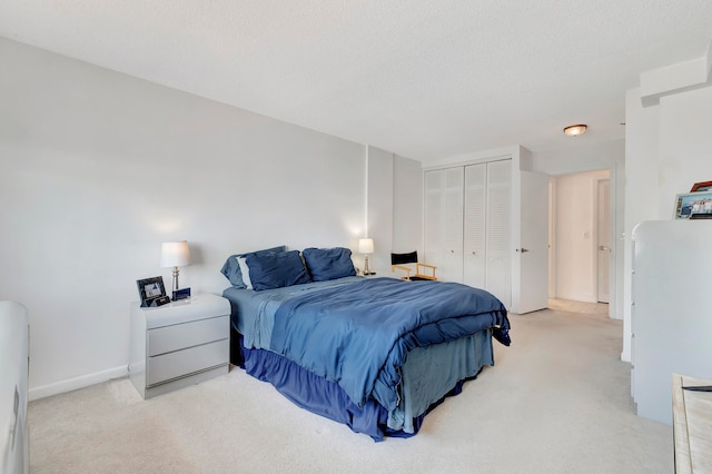 carpeted bedroom with a closet and a textured ceiling