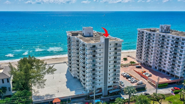 birds eye view of property featuring a water view and a beach view