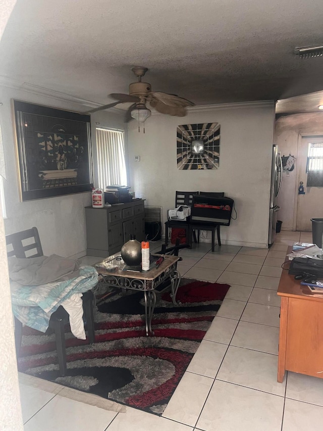 tiled living room with a textured ceiling and ceiling fan