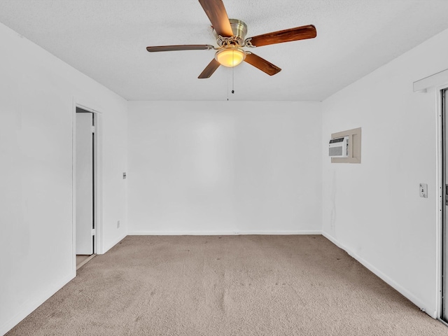 spare room featuring carpet flooring, a wall mounted AC, and ceiling fan