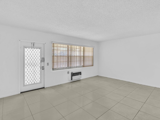 tiled spare room featuring plenty of natural light and a textured ceiling