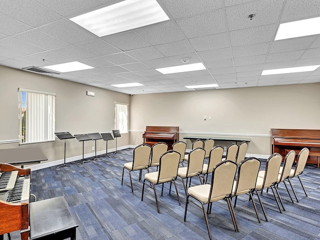 interior space with dark carpet and a drop ceiling