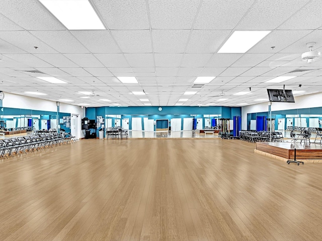 workout area with a drop ceiling and hardwood / wood-style floors