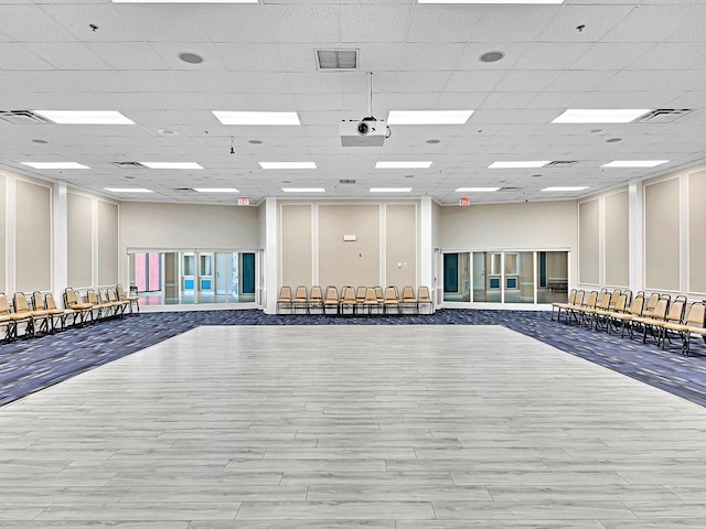 interior space with wood-type flooring and a drop ceiling