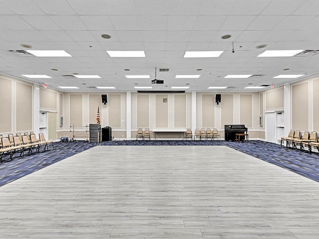 interior space featuring light hardwood / wood-style floors and a drop ceiling