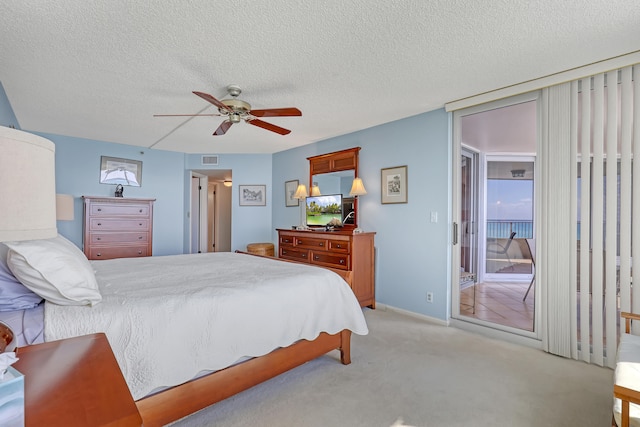 bedroom featuring light colored carpet, access to exterior, ceiling fan, and a textured ceiling