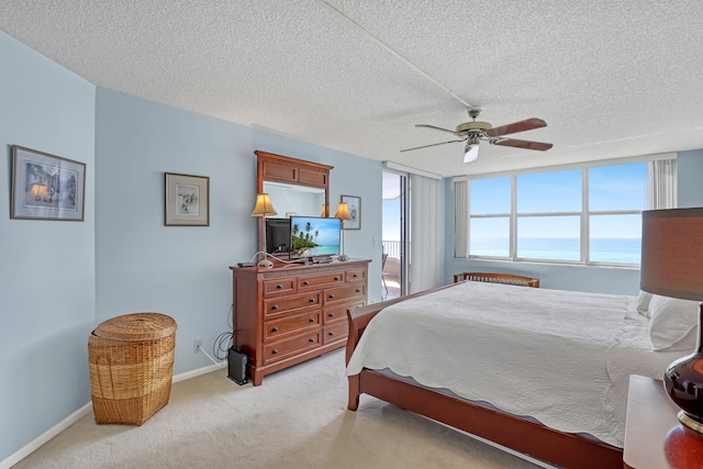 bedroom with light carpet, ceiling fan, and a textured ceiling