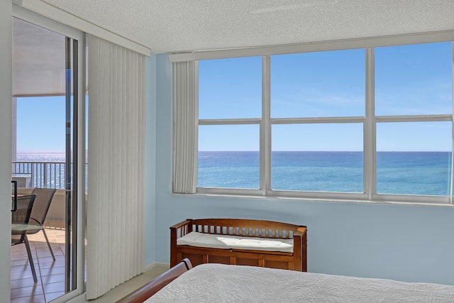 unfurnished bedroom featuring a water view and a textured ceiling