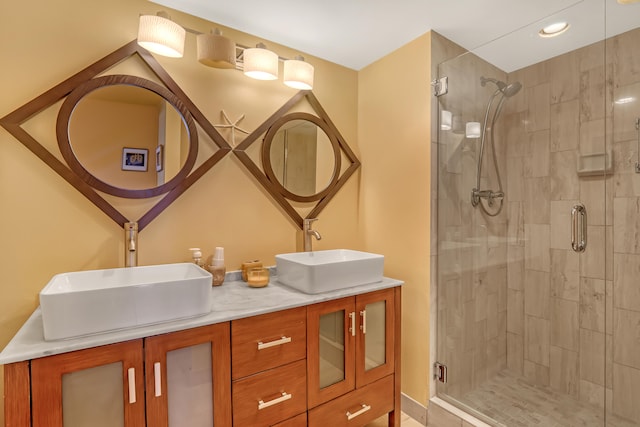 bathroom featuring double sink vanity and an enclosed shower