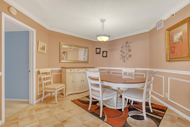 dining room featuring a textured ceiling, light tile floors, and ornamental molding