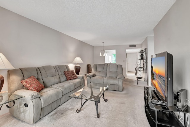 carpeted living room featuring a notable chandelier and a textured ceiling