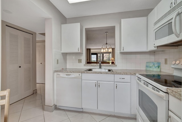 kitchen with white cabinets, white appliances, hanging light fixtures, and sink