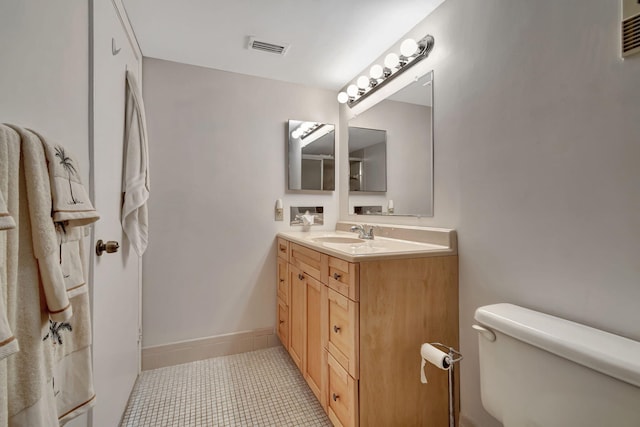 bathroom with tile patterned flooring, vanity, and toilet