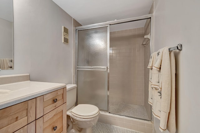 full bathroom featuring a stall shower, toilet, tile patterned floors, and vanity