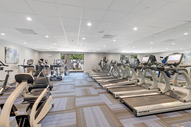 workout area featuring a paneled ceiling and carpet floors