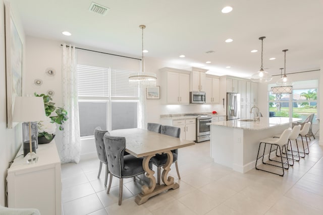 tiled dining area with sink and a chandelier