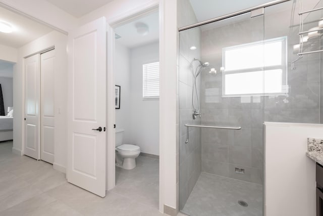 bathroom with tile flooring, a healthy amount of sunlight, an enclosed shower, and vanity