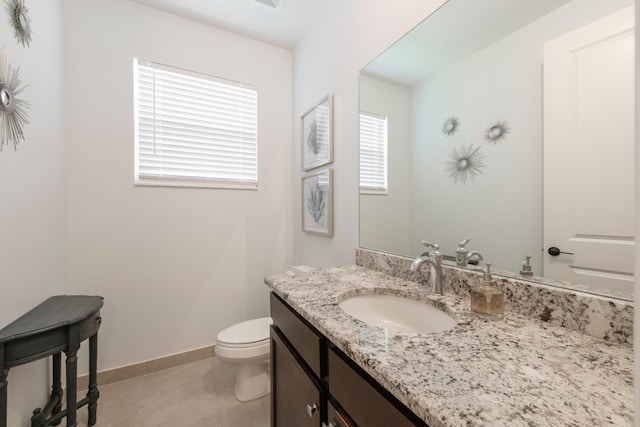 bathroom featuring tile floors, vanity, and toilet