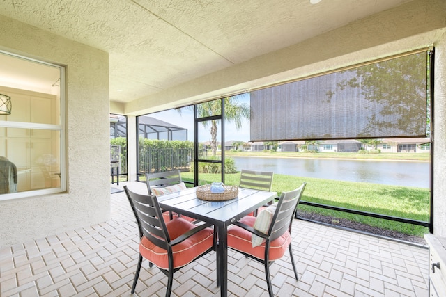 sunroom featuring a water view