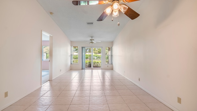 empty room featuring high vaulted ceiling, ceiling fan, and light tile flooring