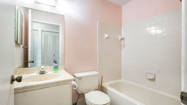 full bathroom with tiled shower / bath, vanity, and toilet