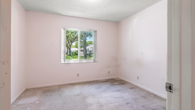 carpeted empty room featuring a textured ceiling