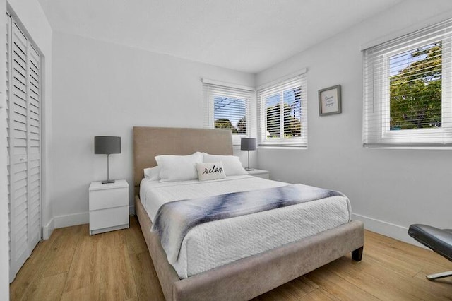 bedroom with multiple windows and light wood-type flooring