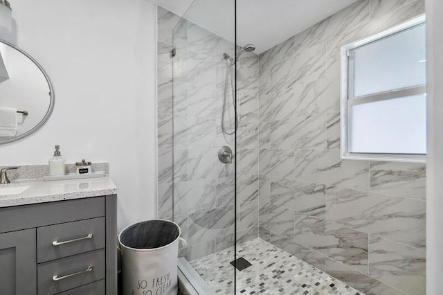 bathroom featuring walk in shower and vanity with extensive cabinet space