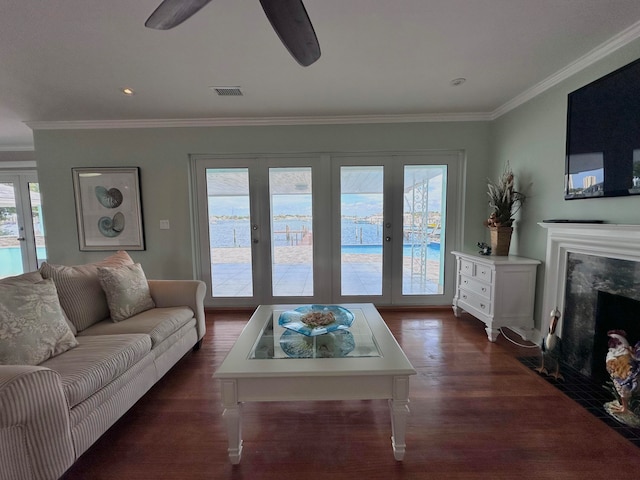 living room featuring ceiling fan, dark wood-type flooring, a high end fireplace, and crown molding