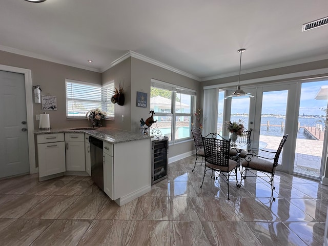 kitchen with stainless steel dishwasher, beverage cooler, white cabinetry, light tile patterned floors, and a water view