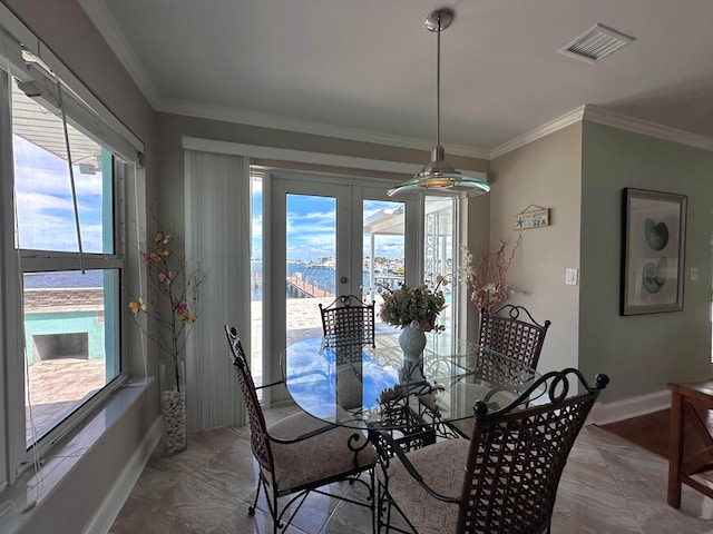 dining room with french doors, crown molding, and a healthy amount of sunlight