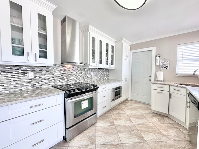 kitchen featuring ornamental molding, decorative backsplash, white cabinetry, stainless steel appliances, and wall chimney range hood