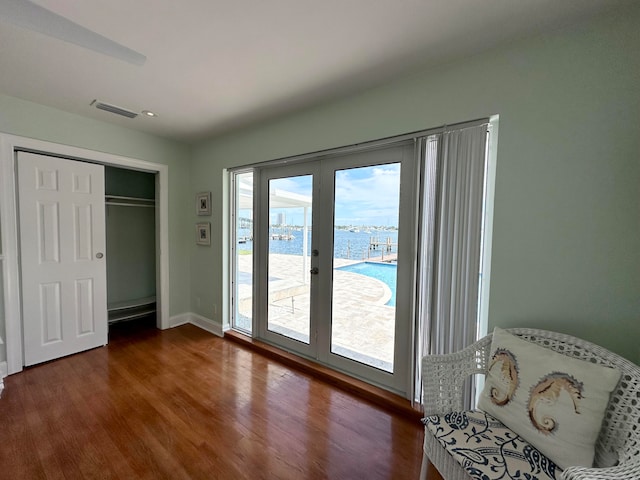 interior space with a closet, access to exterior, dark hardwood / wood-style floors, and french doors