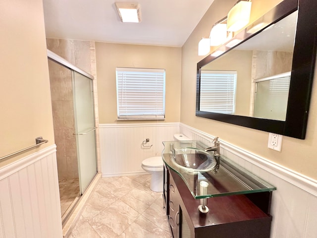 bathroom with tile patterned floors, toilet, a shower with door, and vanity