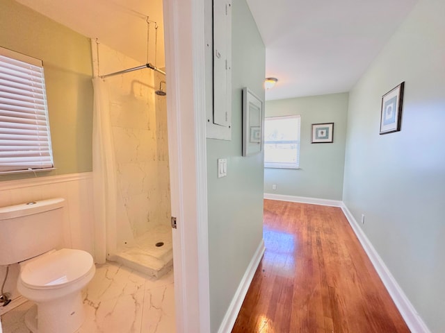 bathroom featuring a shower with curtain, hardwood / wood-style floors, and toilet