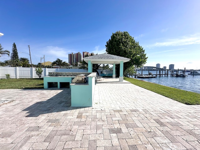 view of patio with a boat dock, a gazebo, and a water view