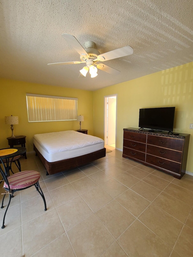 tiled bedroom with a textured ceiling and ceiling fan