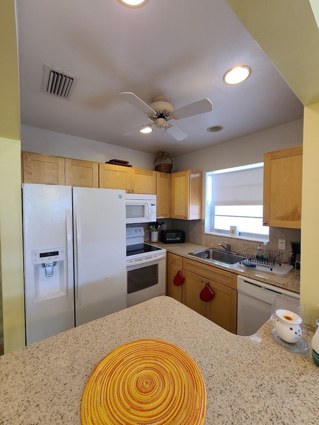 kitchen featuring decorative backsplash, light stone countertops, ceiling fan, and white appliances