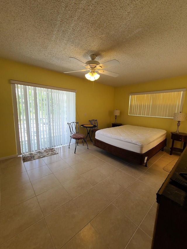 bedroom featuring tile patterned flooring, ceiling fan, and a textured ceiling