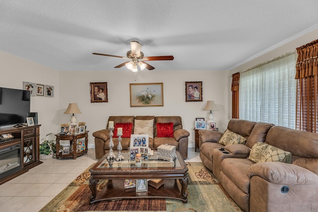 living room featuring a textured ceiling, ceiling fan, and light tile floors