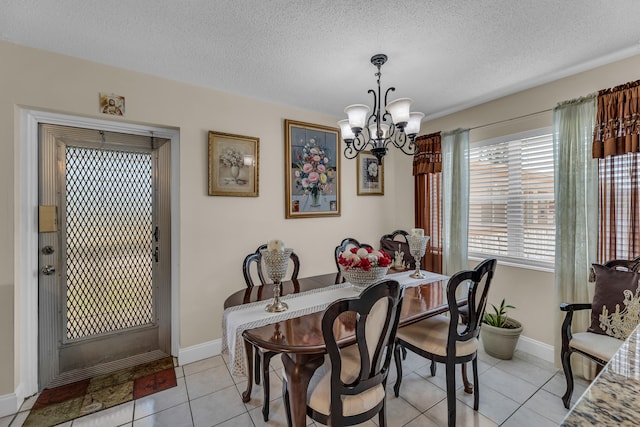 dining area with a notable chandelier, light tile flooring, and a textured ceiling