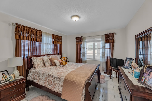 bedroom featuring a textured ceiling and light tile floors