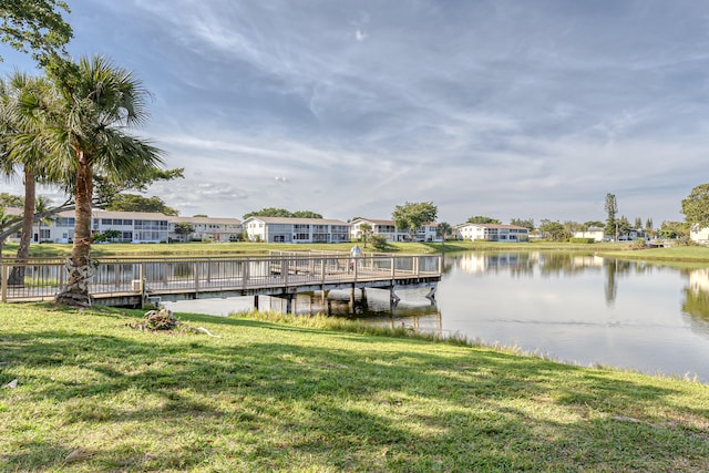 view of dock featuring a water view and a lawn