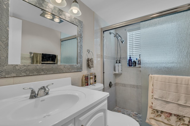 bathroom with vanity, toilet, and a tile shower