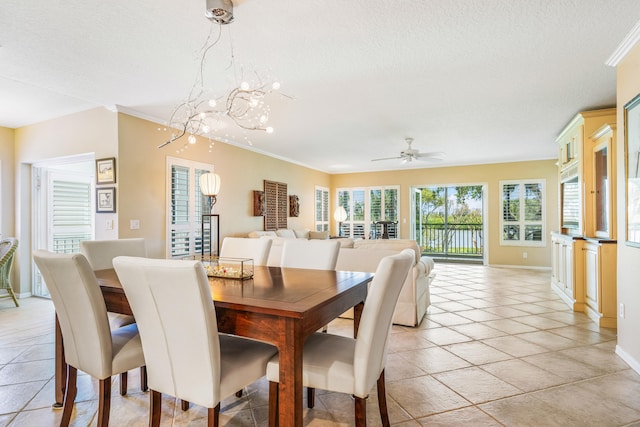 tiled dining area with ornamental molding, ceiling fan with notable chandelier, and a textured ceiling