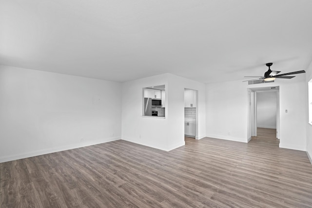 unfurnished living room featuring ceiling fan and dark hardwood / wood-style floors