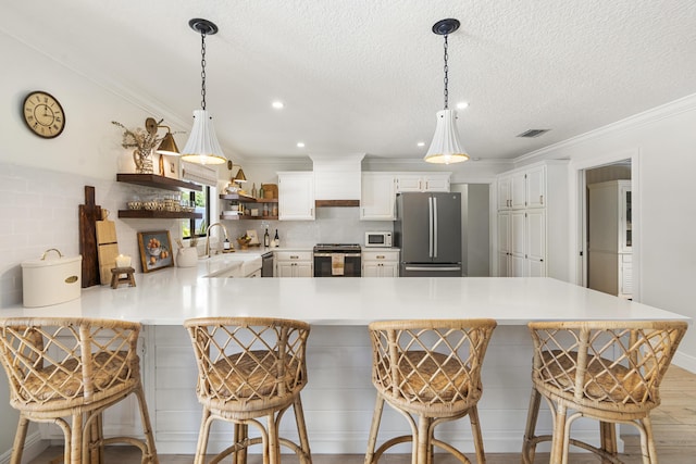 kitchen featuring a kitchen bar, kitchen peninsula, stainless steel appliances, and tasteful backsplash