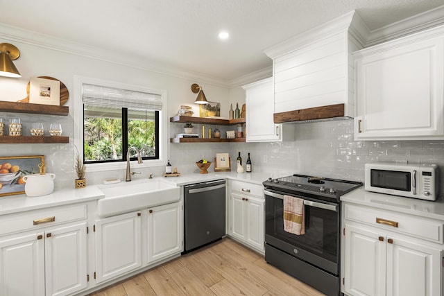 kitchen featuring backsplash, dishwasher, sink, stainless steel electric range oven, and white cabinets